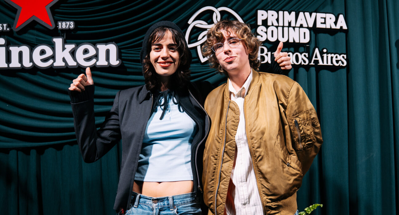 Dos invitados posan ante el backdrop del evento, con los logos de Primavera Sound Buenos Aires y Heineken detrás.